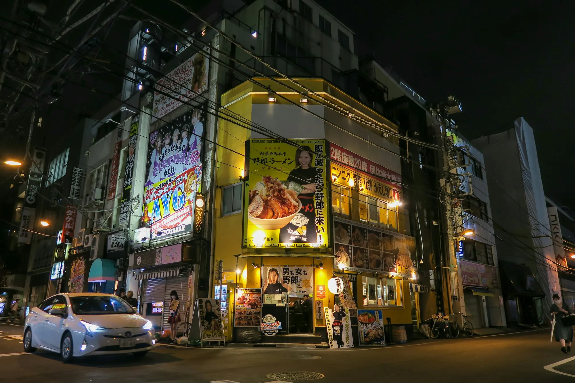 Gece Tokyo sokağında kırmızı *noren* asılı küçük ramen dükkânı