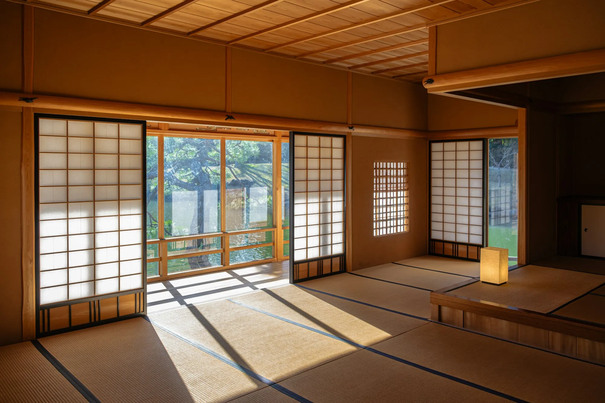 Tatami döşeli ryokan odasında alçak masa ve futon hazırlığı